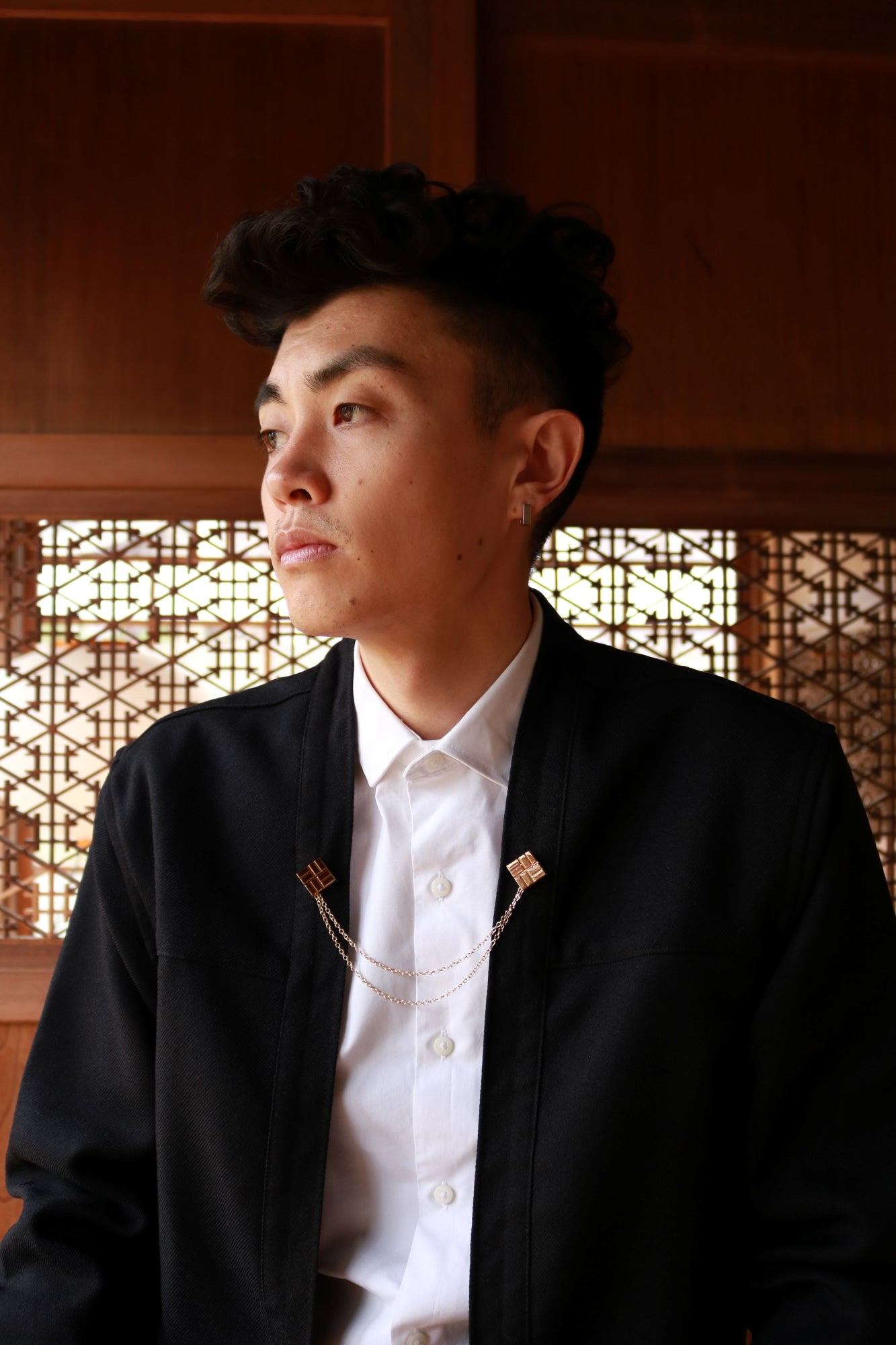 AKASHI-KAMA Technical Black Noragi Jacket layered over white shirt with gold Himo Brooch Pin accessory